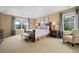 Primary bedroom features large windows, light-colored walls, carpet floors, and tray ceiling with recessed lighting at 17452 W 83Rd Pl, Arvada, CO 80007