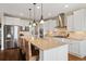 Spacious kitchen with granite counters, stainless steel appliances, white cabinets, and a large island with seating at 17452 W 83Rd Pl, Arvada, CO 80007