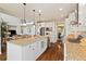 Open kitchen featuring granite counters, stainless appliances, white cabinets, and a large island with seating at 17452 W 83Rd Pl, Arvada, CO 80007