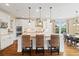Bright kitchen features white cabinets, granite counters, stainless appliances, and a large center island with seating at 17452 W 83Rd Pl, Arvada, CO 80007