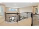 Upstairs landing overlooking the main level featuring iron spindles, carpeted floors, and a large window at 17452 W 83Rd Pl, Arvada, CO 80007