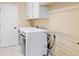 Bright laundry room with cabinets, washer and dryer, and a drying rack at 17452 W 83Rd Pl, Arvada, CO 80007