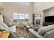 Bright living room with large windows, a fireplace, and plush seating at 17452 W 83Rd Pl, Arvada, CO 80007