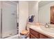 The bathroom features a clear glass shower, wood-framed mirror, and vanity with a wood-stained cabinet at 2299 Ranch Dr, Westminster, CO 80234