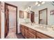 Bathroom featuring double sinks with wood cabinets and an open doorway to the shower at 2299 Ranch Dr, Westminster, CO 80234