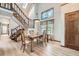 Elegant dining area with a staircase, light fixture and a decorative stained glass window above at 2299 Ranch Dr, Westminster, CO 80234
