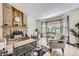 Bright living room featuring a cozy brick fireplace and large window allowing ample natural light at 2299 Ranch Dr, Westminster, CO 80234