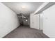 Unfinished basement features gray carpet, white walls, and a staircase at 7484 E Princeton Ave, Denver, CO 80237
