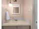 Bathroom with an under mounted sink, patterned mirror, and vintage hanging light fixture at 7484 E Princeton Ave, Denver, CO 80237