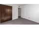 Empty bedroom with a closet, a door to the hallway, and carpet floors at 7484 E Princeton Ave, Denver, CO 80237