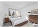 Traditional bedroom with a wood bed frame, dresser, and neutral colored walls at 7484 E Princeton Ave, Denver, CO 80237