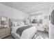 Bright bedroom with a tufted headboard, large window, and neutral décor at 7484 E Princeton Ave, Denver, CO 80237
