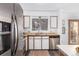 Well-lit kitchen with stainless steel appliances, bright cabinets, and cozy breakfast bar at 7484 E Princeton Ave, Denver, CO 80237