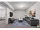Finished basement living room features a comfortable gray sofa, accent chair, and modern decor at 7484 E Princeton Ave, Denver, CO 80237