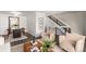 Open-concept living area with sleek staircase, contemporary decor, and comfortable seating at 7484 E Princeton Ave, Denver, CO 80237