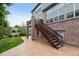 Backyard featuring a concrete patio, manicured lawn, and stairs leading to an upper-level deck at 26155 E Euclid Dr, Aurora, CO 80016