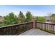 View from a deck with wood railings overlooking lush greenery and neighboring houses at 26155 E Euclid Dr, Aurora, CO 80016