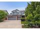 Charming two-story home with attached two car garage, landscaped yard, and sunny blue sky at 26155 E Euclid Dr, Aurora, CO 80016