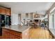 Open concept kitchen with island, hardwood floors, and view to the living room at 26155 E Euclid Dr, Aurora, CO 80016