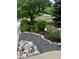 Landscaped front yard featuring colorful flowers, mature trees, and river rock at 26155 E Euclid Dr, Aurora, CO 80016
