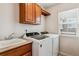 Convenient laundry room with a washing machine, dryer, sink, overhead cabinets and a bright window at 26155 E Euclid Dr, Aurora, CO 80016
