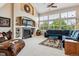 Spacious living room with fireplace, large windows overlooking nature, and comfortable seating arrangements at 26155 E Euclid Dr, Aurora, CO 80016