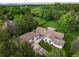 An aerial view of a home showcasing its spacious yard, mature trees, and charming architecture near a golf course at 1 Club Ln, Littleton, CO 80123