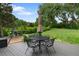 Backyard patio with an umbrella-covered table and chair set, swing set, and lush green lawn, perfect for relaxation at 1 Club Ln, Littleton, CO 80123