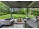 Inviting backyard featuring a covered patio with a fire pit, lush green lawn, and mature trees at 1 Club Ln, Littleton, CO 80123