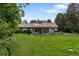 A spacious backyard featuring a covered patio, a lush green lawn, and mature trees, ideal for outdoor activities and gatherings at 1 Club Ln, Littleton, CO 80123