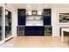 Stylish bar area with navy cabinets, wine coolers, shelving, and glassware, perfect for entertaining at 1 Club Ln, Littleton, CO 80123