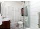 Modern bathroom featuring a glass-enclosed shower, sleek vanity, and stylish white wood plank-style wall tiles at 1 Club Ln, Littleton, CO 80123