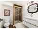 Bathroom featuring a white vanity with gold accents, mosaic tiled shower, and decorative mirror at 1 Club Ln, Littleton, CO 80123