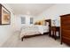 Bedroom showcasing a bed with decorative pillows, carpet, and a traditional nightstand with a lamp at 1 Club Ln, Littleton, CO 80123