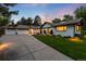 Beautiful home exterior with a well-manicured lawn and a long driveway leading to a two-car garage at 1 Club Ln, Littleton, CO 80123