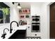 A kitchen with stainless steel appliances, white cabinetry, and a built-in oven at 1 Club Ln, Littleton, CO 80123