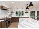 The kitchen features a stunning waterfall island, stainless steel appliances, and backyard views at 1 Club Ln, Littleton, CO 80123
