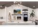 Bright living room with white brick fireplace, wood storage, fish tank, and modern lighting fixture at 1 Club Ln, Littleton, CO 80123