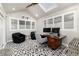 Bright office featuring a skylight, modern desk with dual monitors, two chairs, and a patterned carpet at 1 Club Ln, Littleton, CO 80123