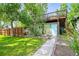 Backyard view of additional structure with deck, lawn, and landscaping at 5355 S Windermere St, Littleton, CO 80120