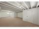 Carpeted basement with exposed ceiling, white walls, and a doorway leading to another room at 5355 S Windermere St, Littleton, CO 80120