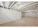 A finished basement offers space for storage or recreation with carpet and bright white walls at 5355 S Windermere St, Littleton, CO 80120
