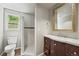 Updated bathroom featuring a vanity, tile shower, modern fixtures, and a bright window at 5355 S Windermere St, Littleton, CO 80120
