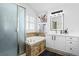 Well-lit bathroom with tub, vanity, mirror, and shower with glass doors at 9877 Arthur Ln, Highlands Ranch, CO 80130