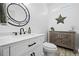 Modern powder room featuring a round mirror, sleek fixtures, and a rustic-style storage cabinet at 9877 Arthur Ln, Highlands Ranch, CO 80130