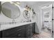 Beautiful bathroom featuring dual sinks, marble countertops, modern lighting, and luxury finishes at 9877 Arthur Ln, Highlands Ranch, CO 80130