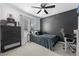 Stylish bedroom featuring a dark accent wall, modern desk, and ceiling fan at 9877 Arthur Ln, Highlands Ranch, CO 80130