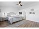 Bright bedroom with white walls, ceiling fan and wood-look floors, plus an upholstered king bed at 9877 Arthur Ln, Highlands Ranch, CO 80130