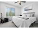 Bright bedroom featuring a large window, comfortable bed, ceiling fan, and stylish ocean artwork at 9877 Arthur Ln, Highlands Ranch, CO 80130
