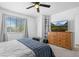 Bedroom featuring a ceiling fan, large window and wooden dresser at 9877 Arthur Ln, Highlands Ranch, CO 80130
